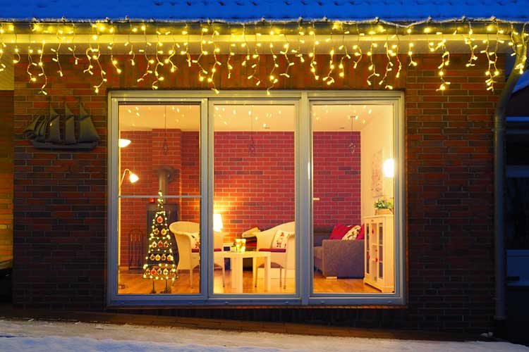 Blick vom Garten durchs Fenster in das weihnachtlich geschmückte Wohnzimmer