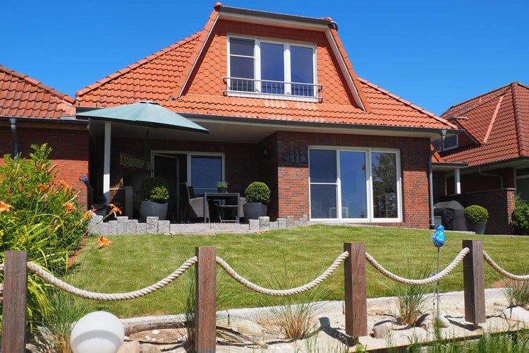 Der Garten mit Wiese und Terrasse vom Feld aus gesehen