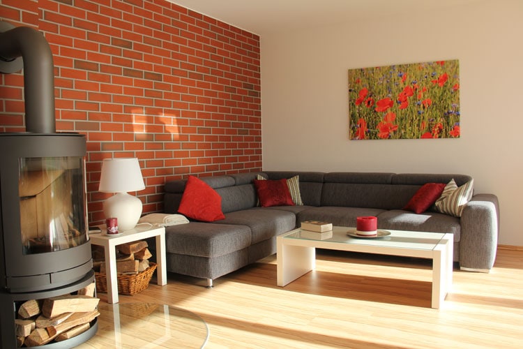 Wohnzimmer mit großem, gemütlichem Ecksofa und Kamin